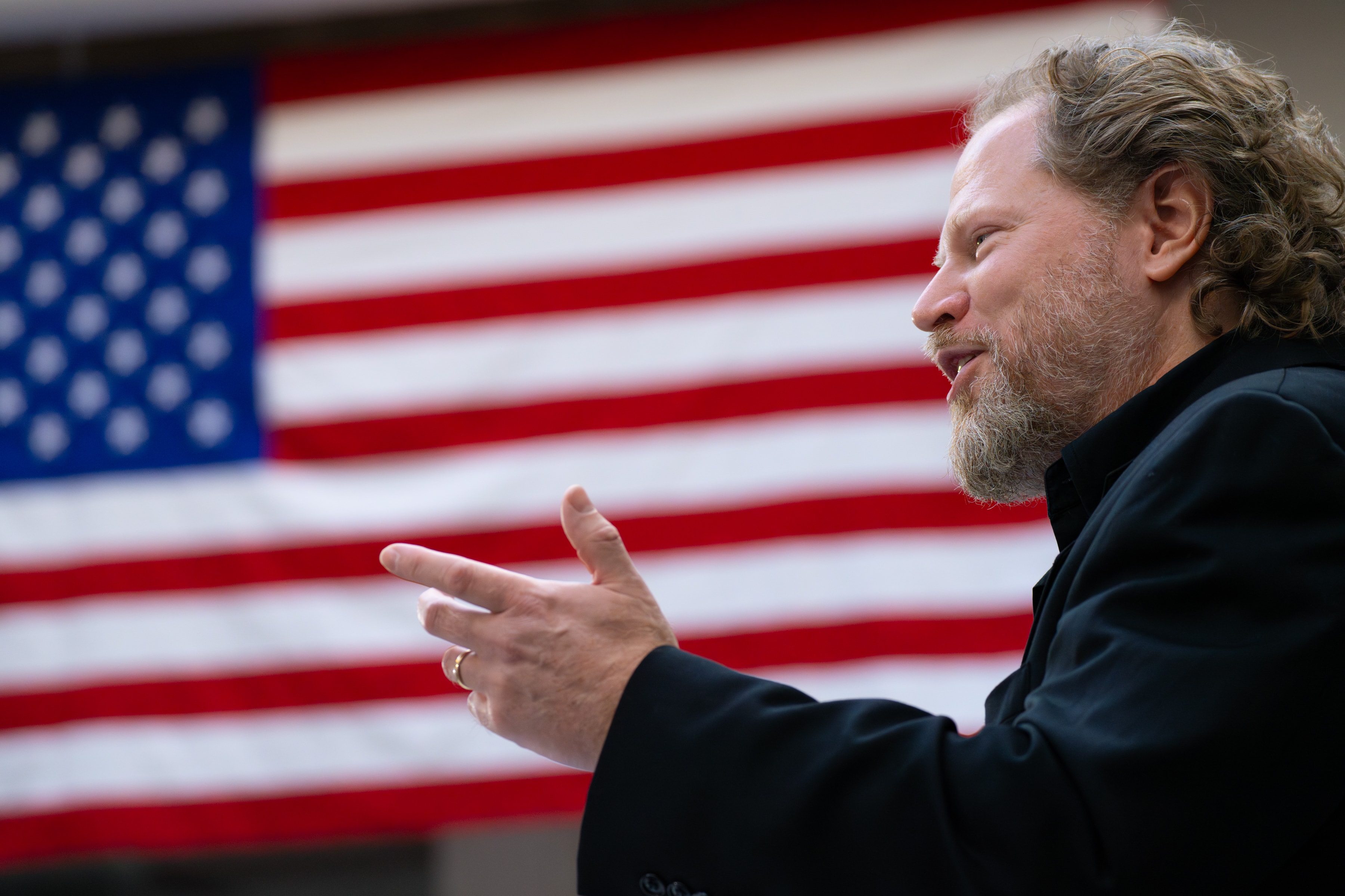 Morgan Marietta speaking in front of an American flag